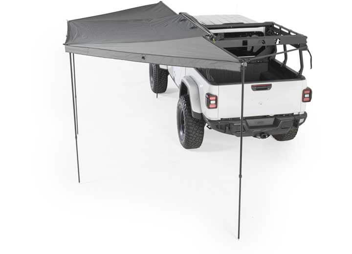 Smittybilt 180° Awning over a vehicle, providing shade and protection for outdoor activities.