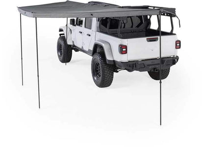 Smittybilt 180° awning providing shade over a white off-road vehicle, designed for rugged outdoor use.