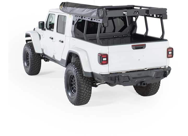 White Jeep truck with Smittybilt 180° awning deployed, showcasing spacious outdoor shade coverage.
