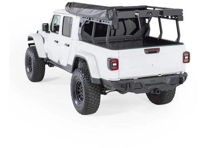 White Jeep truck with Smittybilt 180° awning deployed, showcasing spacious outdoor shade coverage.